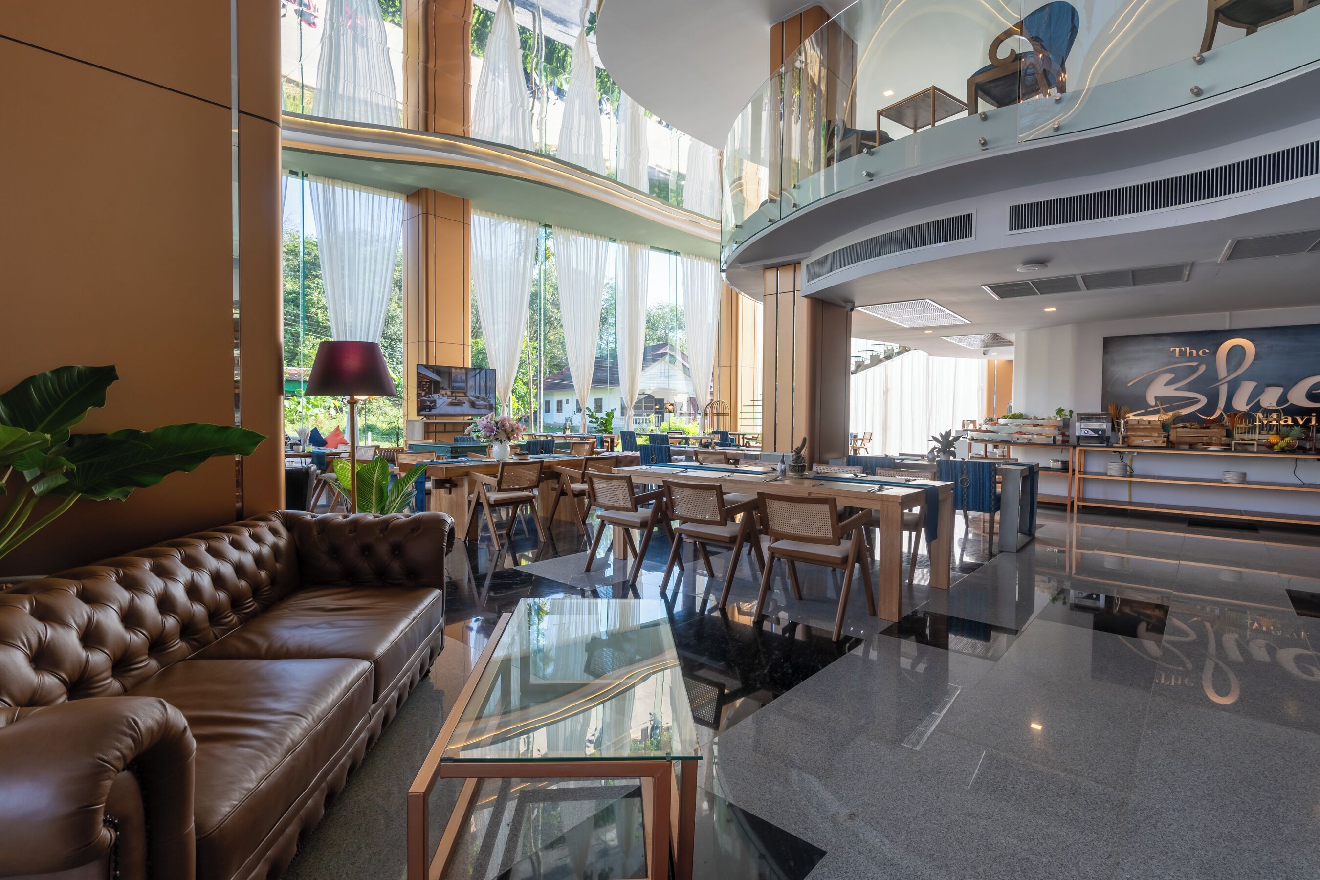 A spacious lobby with a leather sofa, glass coffee table, and modern furniture.