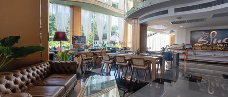 A spacious lobby with a leather sofa, glass coffee table, and modern furniture.