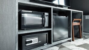 A kitchen with a microwave, refrigerator, and a security system.
