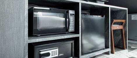 A kitchen with a microwave, refrigerator, and a security system.