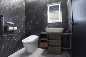 Een aparte badkuip en douche, een haardroger, badjassen, pantoffels