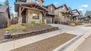 A modern residential building with a stone facade, large windows, and a covered front porch. - 4BR w hot tub, gas fireplace, near NAU (Flagstaff)