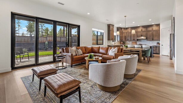 A spacious living area with a large sliding glass door leading to a backyard, a kitchen with wooden cabinets, and a dining area with a table and chairs. - 4BR w hot tub, gas fireplace, near NAU (Flagstaff)
