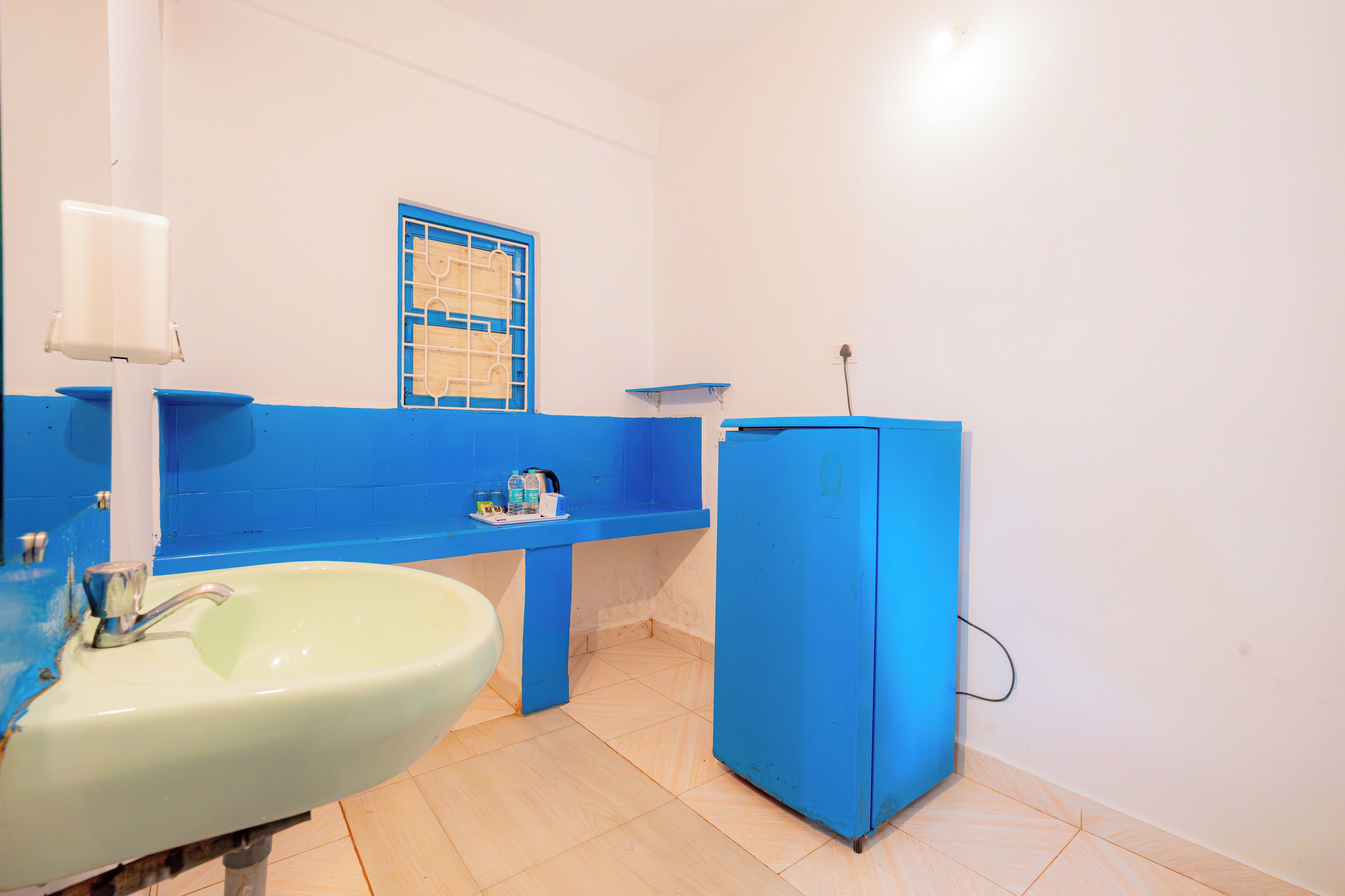 A bathroom with a white sink, blue countertop, and a blue cabinet.