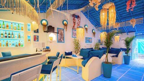 A bar area with seating, a counter with bottles, and hanging decorations. - Viik wellness inn 3-Star Resort in Arambol Beach (Arambol)