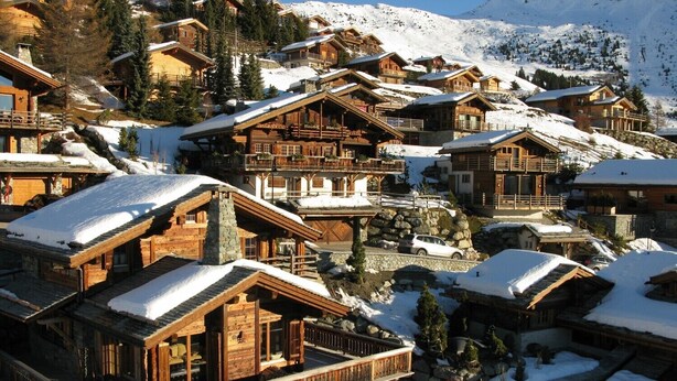 A cluster of wooden chalets with balconies, set against a snowy mountain backdrop. - MAGNIFICENT VIEWS FROM THE HEART OF VERBIER-NEXT TO THE NEW SPORTS CENTER (Val de Bagnes)