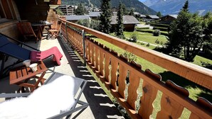 A balcony with wooden railings, a table with chairs, and a view of a mountainous landscape. - MAGNIFICENT VIEWS FROM THE HEART OF VERBIER-NEXT TO THE NEW SPORTS CENTER (Val de Bagnes)