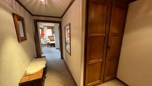 A hallway with a wooden bench, a door, and a view into a dining area. - MAGNIFICENT VIEWS FROM THE HEART OF VERBIER-NEXT TO THE NEW SPORTS CENTER (Val de Bagnes)