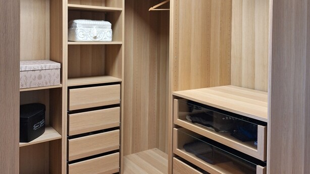 Ein Holzkoffer mit mehreren Ablagen, Schubladen und Platz zum Aufhängen.