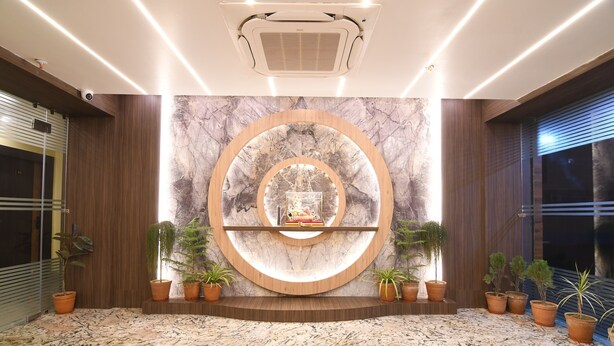 Un hall d’entrée doté d’un sol en marbre, d’une étagère circulaire en bois ornée de plantes et d’un design de plafond moderne.