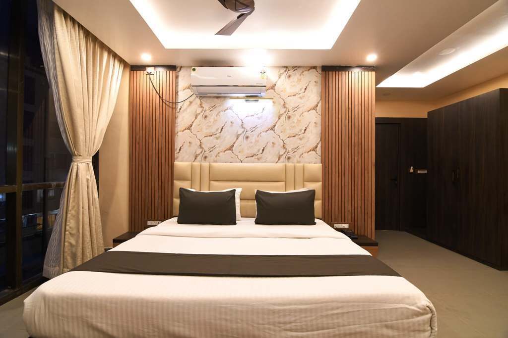 Een moderne slaapkamer met een groot bed, een hoofdbord met verticale houten latten, een airconditioning en uitzicht op de stad 's nachts.