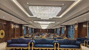 Una lussuosa hall d'albergo con un maestoso lampadario, posti a sedere confortevoli e arredi eleganti.