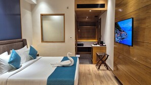 Camera d'albergo con un letto, una TV, una parete in legno e vista su una località costiera.