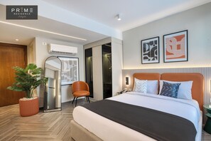 A modern hotel room with a large bed, a potted plant, a mirror, and a wardrobe. - Prime Residence Heliopolis (Cairo)