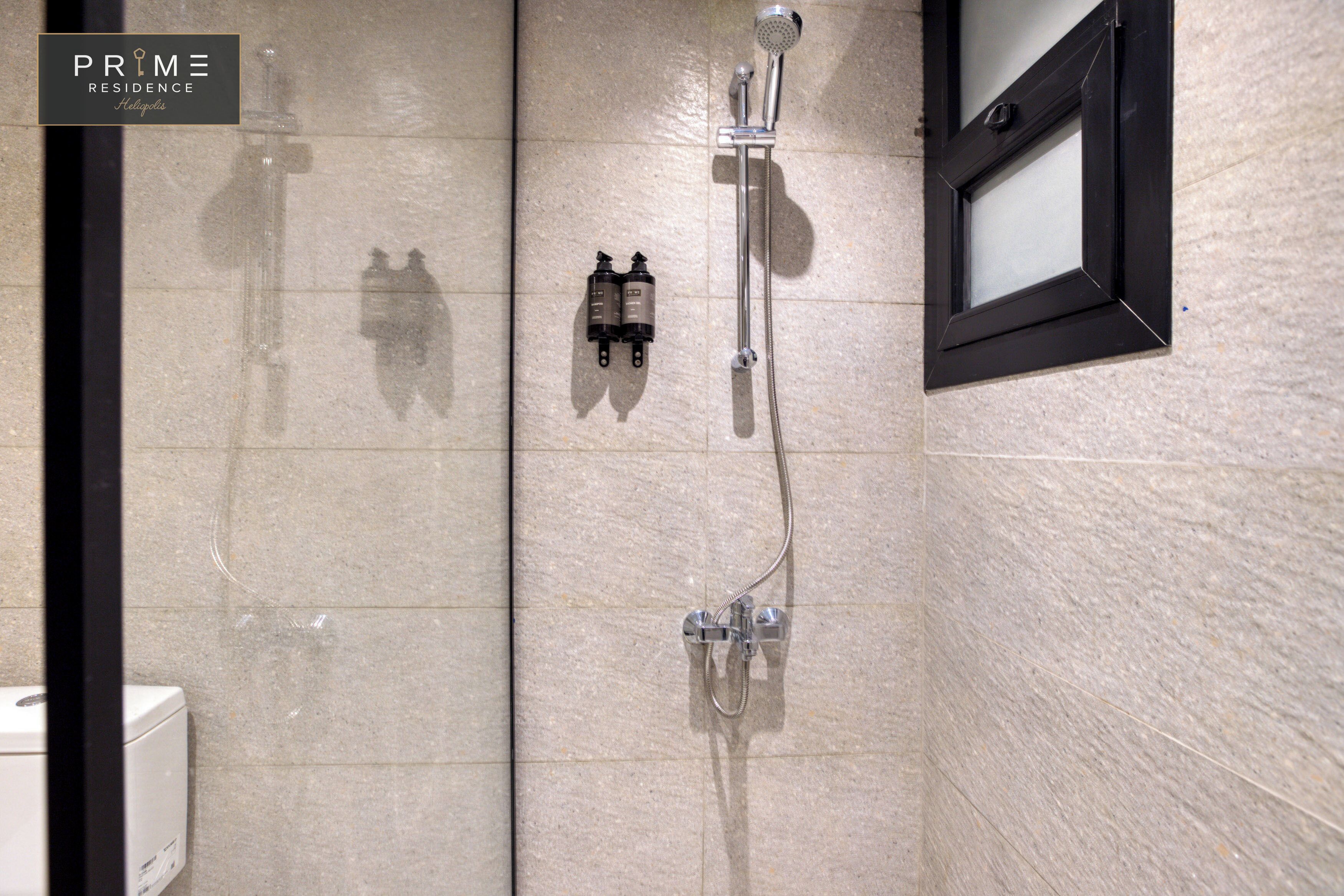 A shower with a handheld showerhead and a wall-mounted faucet.