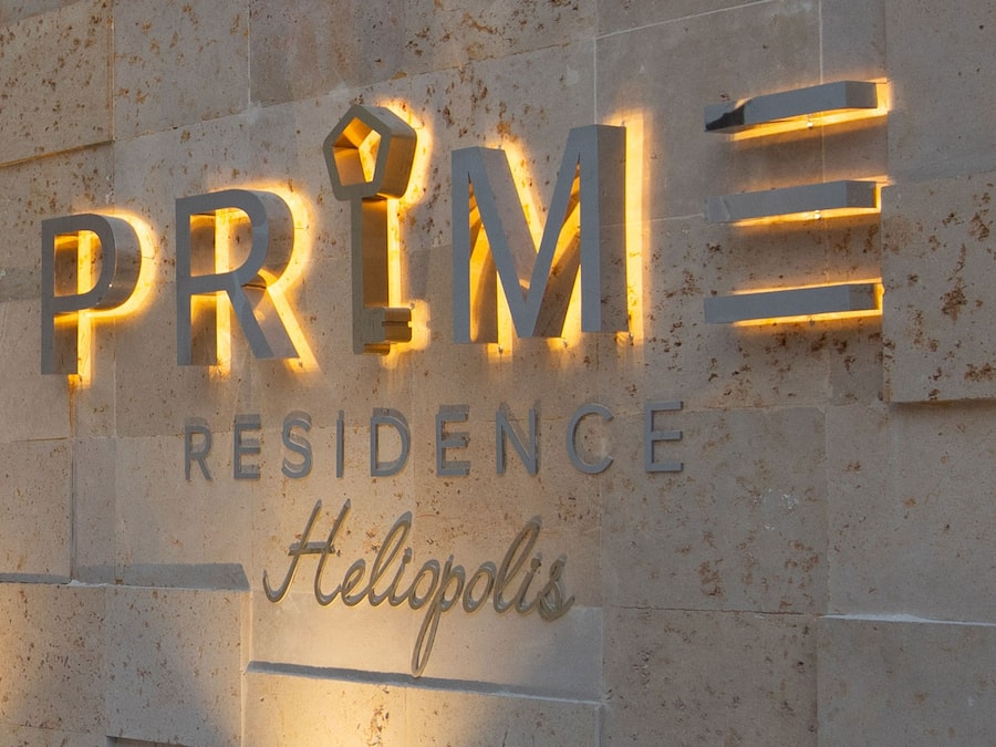 A sign for 'PRIME Residence' with illuminated letters and the word 'Hellopolis' below.