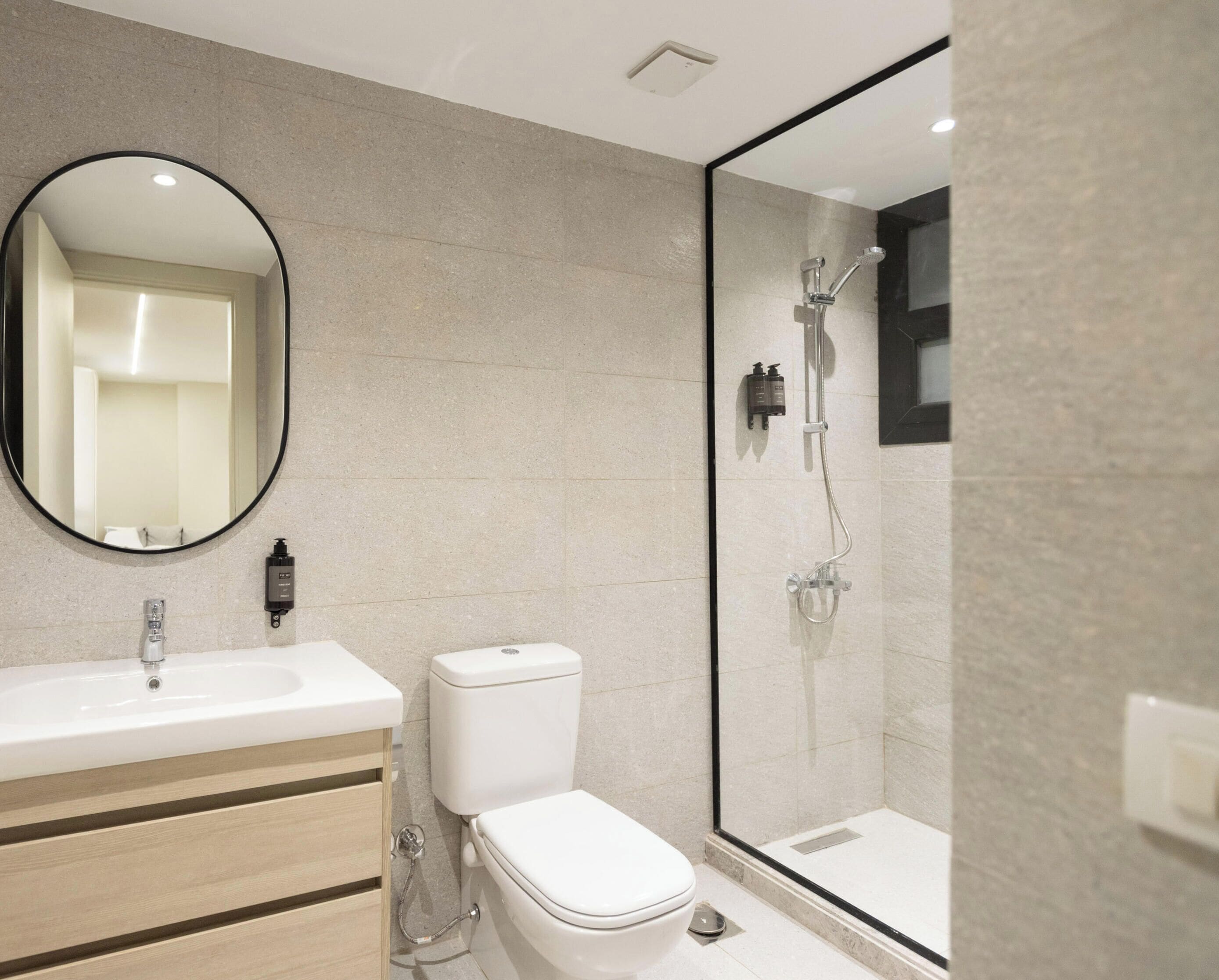 A modern bathroom with a sink, toilet, and glass-enclosed shower.