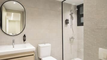 Une salle de bain moderne avec un lavabo, des toilettes et une douche à parois de verre.