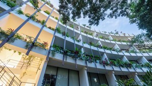 A multi-story building with balconies adorned with lush greenery and plants. - Welcome to Mistiq Temple II in Tulum, where modern luxury meets the natural beauty of the region (Tulum)