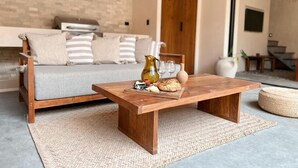 A cozy living area with a wooden coffee table, a sofa, and a wicker rug. - This villa is a 2 bedroom(s), 2.5 bathrooms, located in Tulum, Quintana Roo. (Tulum)