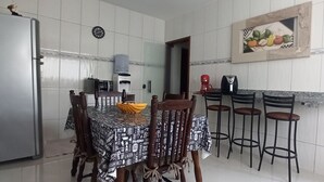 Een eetruimte met een tafel bedekt met een zwart-wit geruit tafelkleed, omringd door houten stoelen. Op de tafel staat een kleine gele schaal.