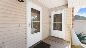 A house entrance with two white doors, a black outdoor light fixture, and a small porch area. - Close to HWY 76 Strip!  Great Location! (Branson)