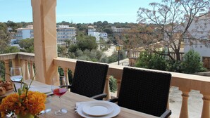 A table set for two with a view of a town. - Torre al Mar: sea view and pool, 150m to the beach, 8 pers., aircon, ETV/5162  (Cala Santanyí)