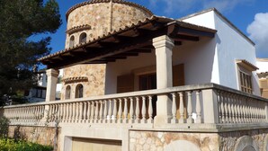 A building with a stone facade, a balcony with balustrades, and a circular stone structure on the roof. - Torre al Mar: sea view and pool, 150m to the beach, 8 pers., aircon, ETV/5162  (Cala Santanyí)