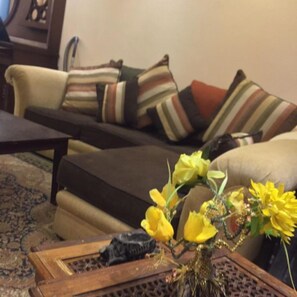 Relax in this inviting living room with a comfortable sofa, side table, and vibrant flowers.