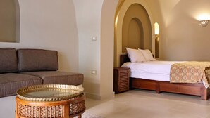Une chambre à coucher avec un lit, un canapé et une petite table.
