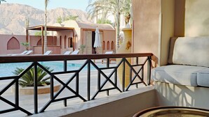 A balcony with a pool, lounge chairs, and a view of a mountainous landscape. - Malkata House Ground Floor Suite, Pool & Dine & Tours (Luxor)
