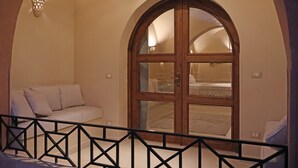 A bedroom with a large arched window, a sofa, and a bed. - Malkata House Ground Floor Suite, Pool & Dine & Tours (Luxor)