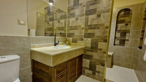 Un bagno con lavandino, specchio e doccia.