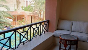 Un balcone con vista piscina, un divano e un piccolo tavolo.