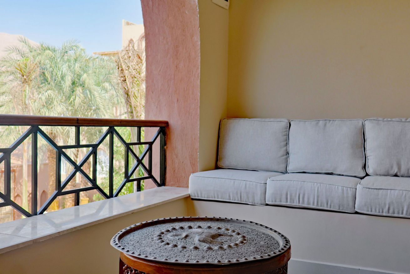 Un balcon avec un canapé blanc et une table décorative.