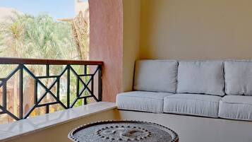 Un balcon avec un canapé blanc et une table décorative.