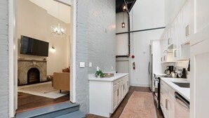 Eine moderne Küche mit weißen Schränken, einem eingebauten Backofen und einer Edelstahl-Spüle.