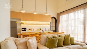 Una sala de estar moderna con un sofá, un comedor y una cocina.