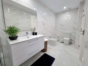 Features a sleek vanity, separate sink and toilet area, and a bidet for convenience.