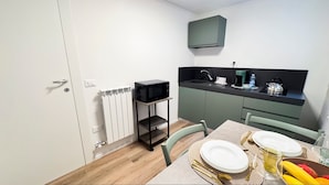 A compact kitchen with a microwave on a shelf, a coffee maker, and a kettle on the counter. - Tre Esse Verde by Ca-sa Check (Chioggia)