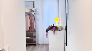 A hallway with a white wardrobe, a hanging plant, and a lamp on a table. - Tre Esse Verde by Ca-sa Check (Chioggia)