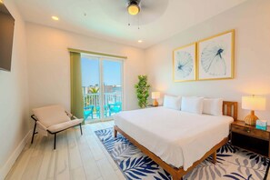 Une chambre d’hôtel avec un lit, une chaise, une table de chevet, une lampe et une vue sur l’extérieur.