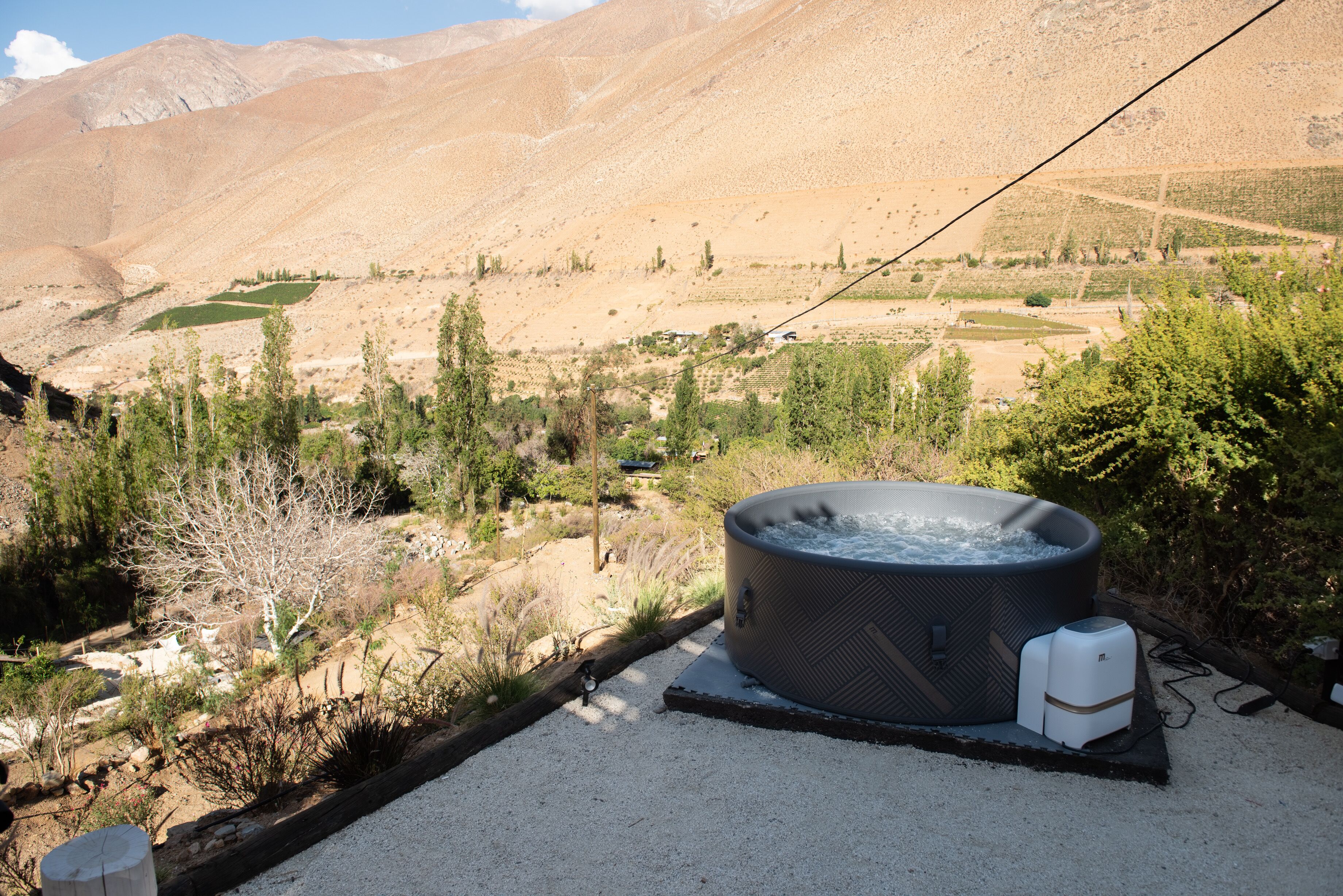 Un jacuzzi en un paisaje desértico con montañas al fondo.