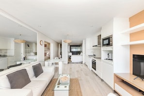Eine moderne Wohnung mit Wohnzimmer, Küche und Essbereich.