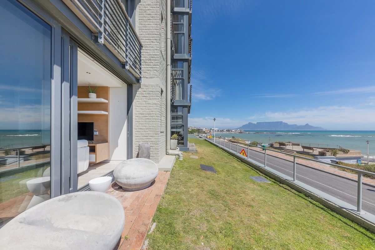 A modern building with a balcony overlooking a coastal view.