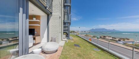 A modern building with a balcony overlooking a coastal view.