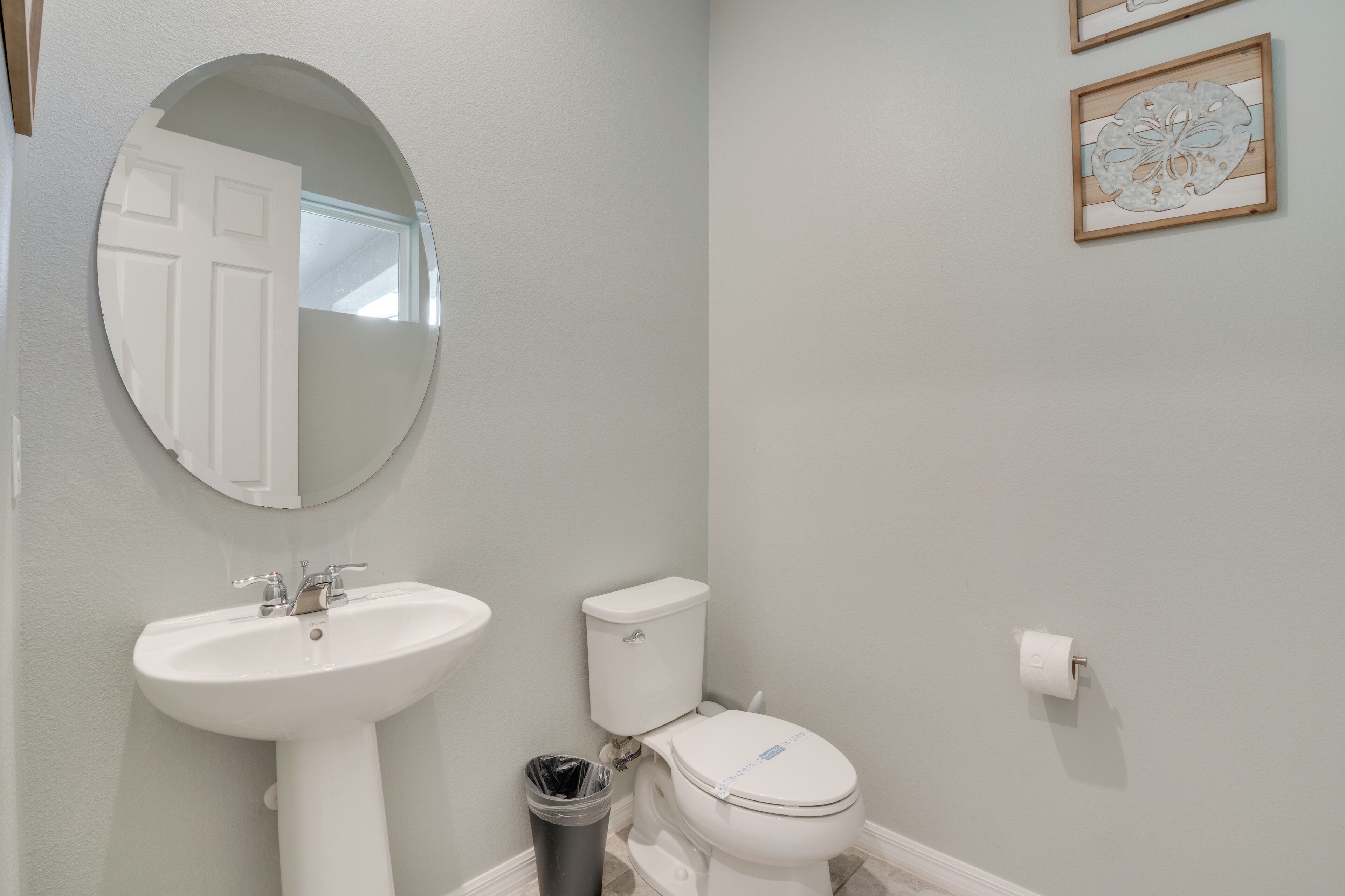 A bathroom with a sink, toilet, and mirror.
