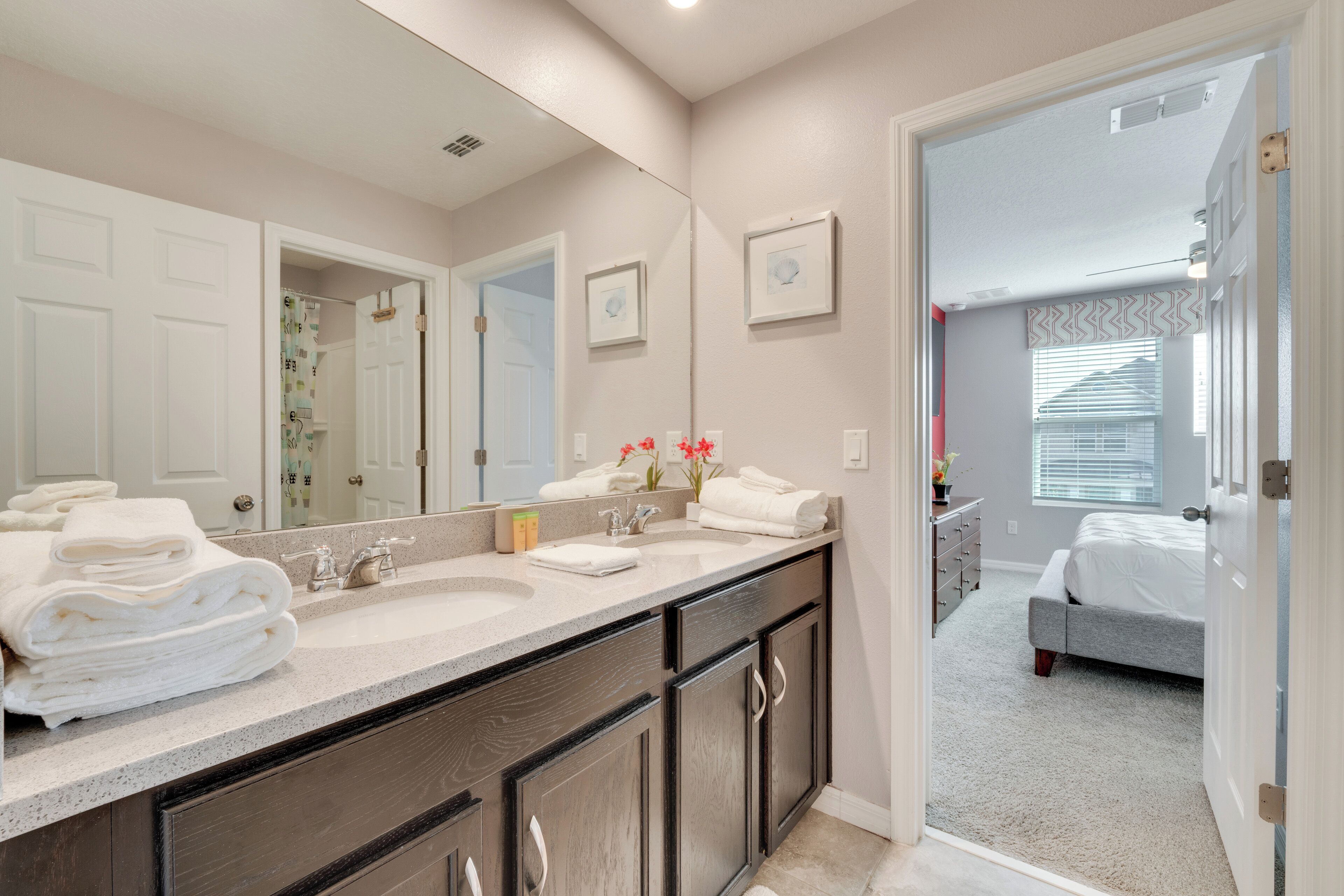 A bathroom with a double sink, dark wooden cabinets, and a large mirror.