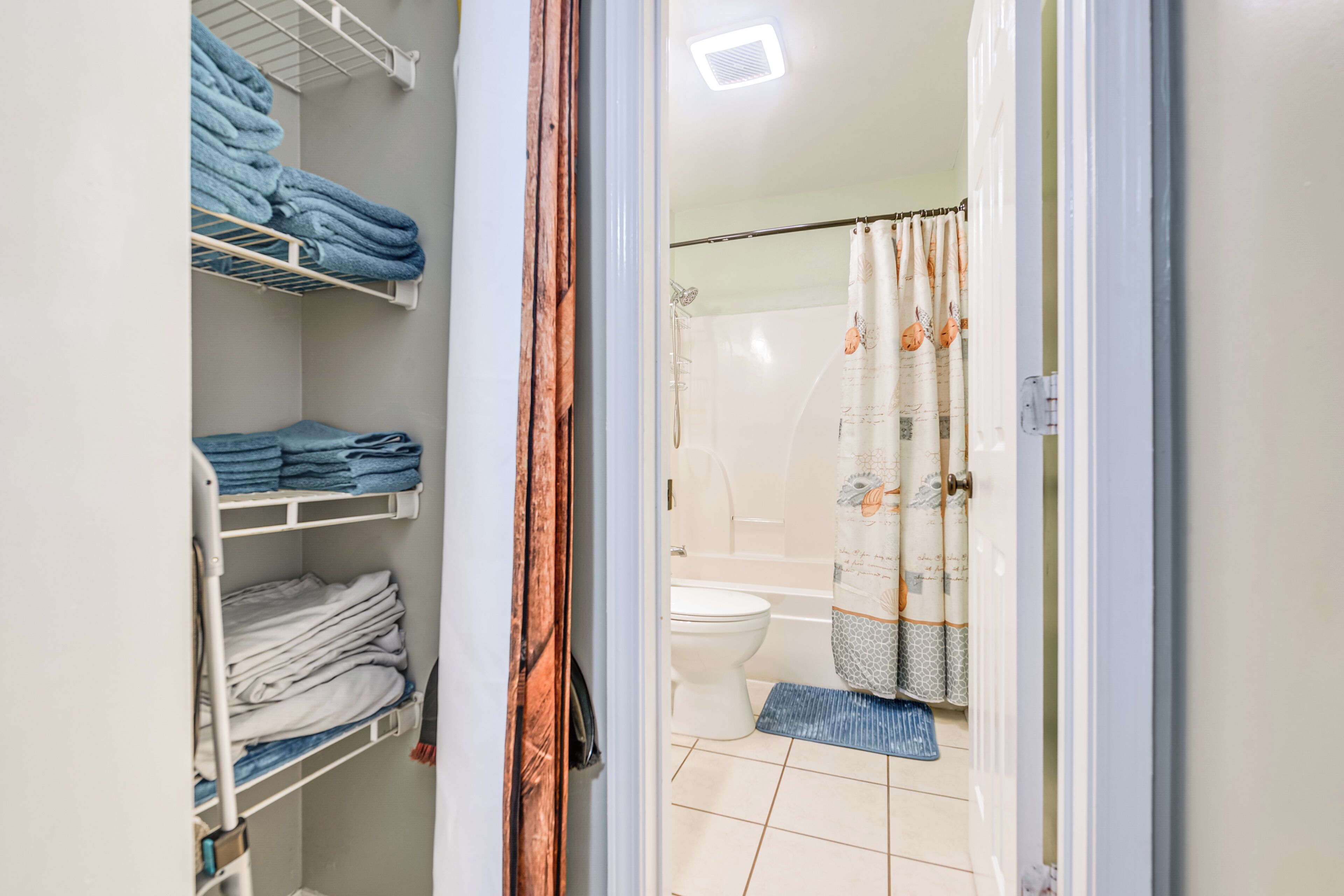 Une salle de bain équipée de toilettes, d’un rideau de douche et d’un porte-serviettes.