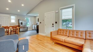 Ein modernes Wohnzimmer mit einer Couch, einem Couchtisch und einem Essbereich mit Stühlen und einem Tisch.